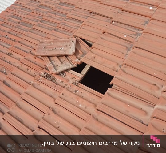 רעפים שבורים על גג עם חור חשוף